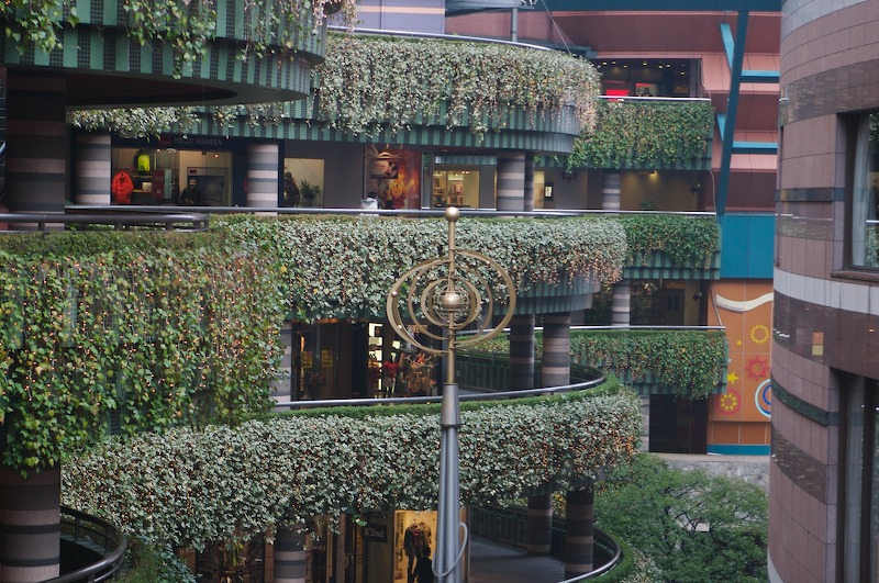 From the edge of the red "stadium" type walkways, you can see the walkways curve back and forth along the canal between the shopping center and Grand Hyatt, these are covered in luscious greenery.