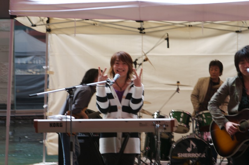 This is a bit blurry; I wasn't trying to take a picture of the female lead singer, but she started giving me the V signs so I snapped one (evidently before the camera focused back on her). ; ;